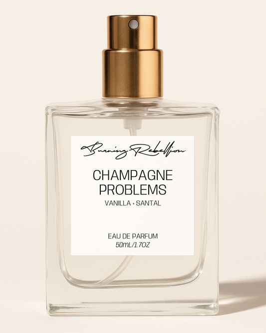 Perfume bottle labeled 'Champagne Problems' by Running Rebel on a beige background
