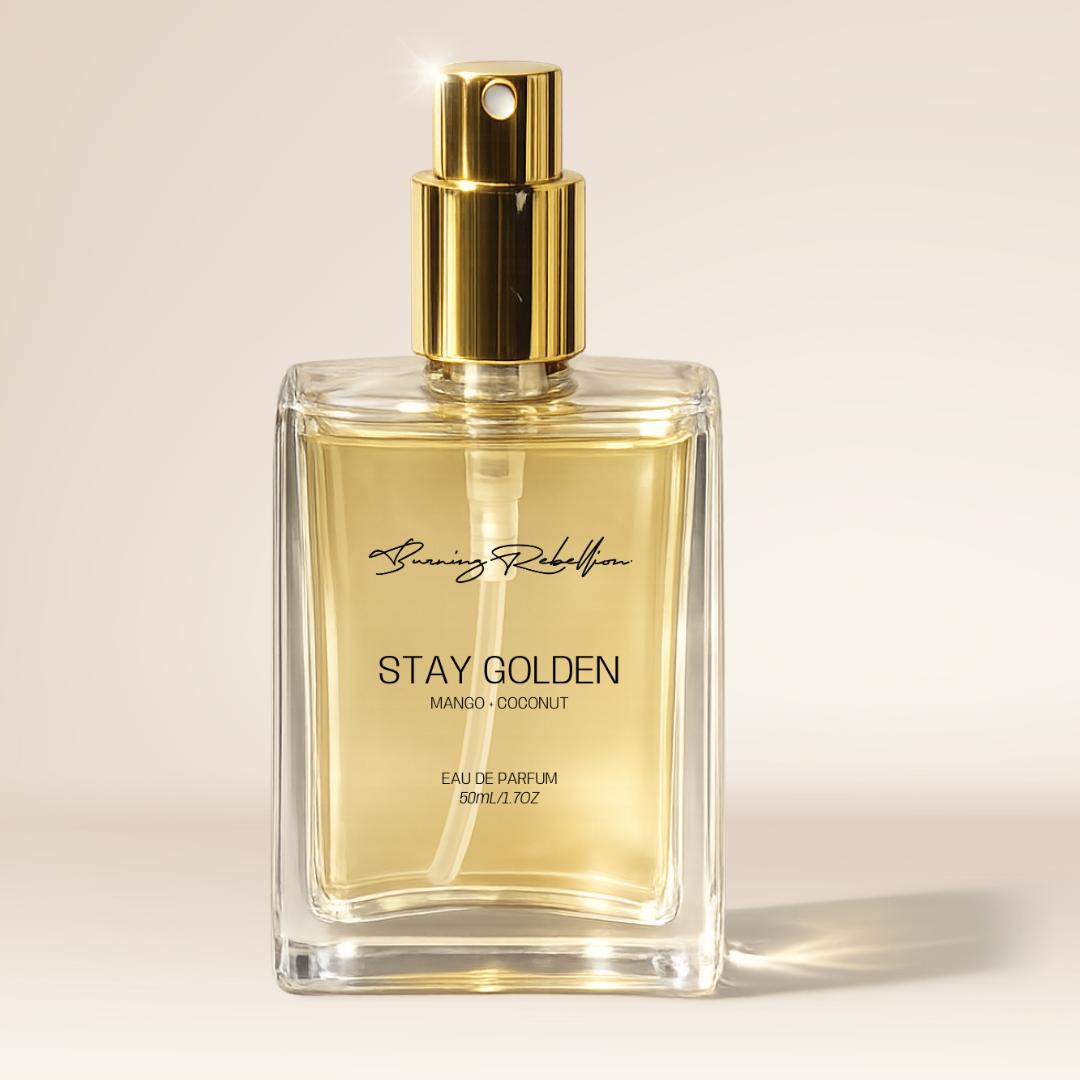 Perfume bottle labeled 'Stay Golden' with gold cap on a beige background